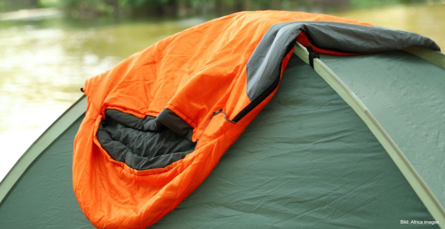Schlafsack liegt auf dem Zelt und lüftet
